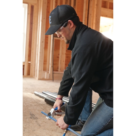 LENOX 12121S1 pipe cutter being used to cut blue pipe in a construction site.