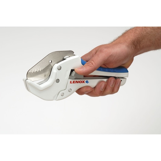 Photo of LENOX 12123R1 PVC pipe cutter in hand, white and blue handle with visible steel blade.
