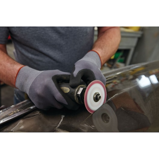 LENOX 1972918 abrasive disc in use on metal surface, photo shows gloved hands operating tool.