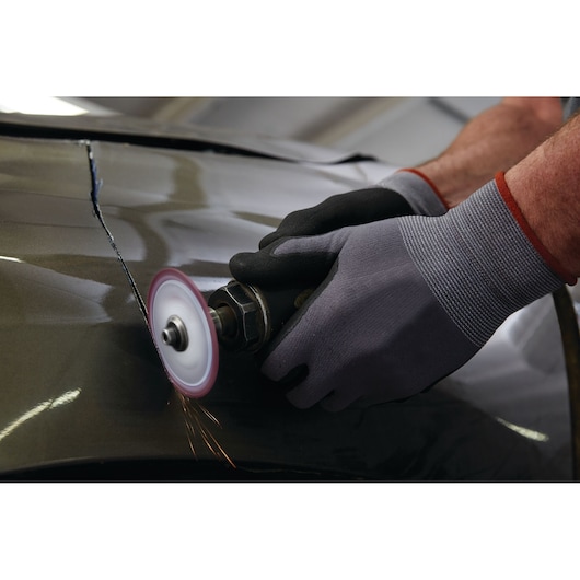 LENOX 1972918 metal cutting wheel grinding metal surface with gloves, action close-up.