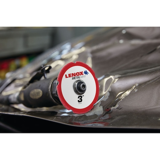 A close-up of a Lenox MetalMax 3-inch cutting disc attached to a power tool, placed on a metallic surface.