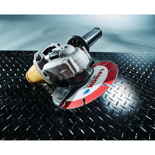 LENOX 1972921 metal cutting circular saw blade attached to power tool on black diamond plate surface.