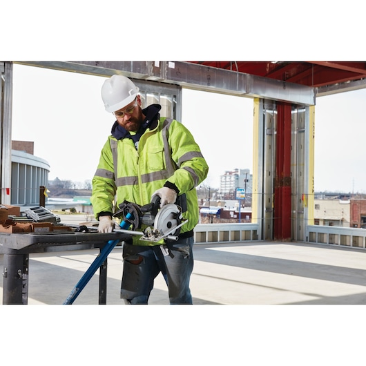 LENOX 1972924 saw blade in use on construction site, worker in high-visibility jacket using circular saw