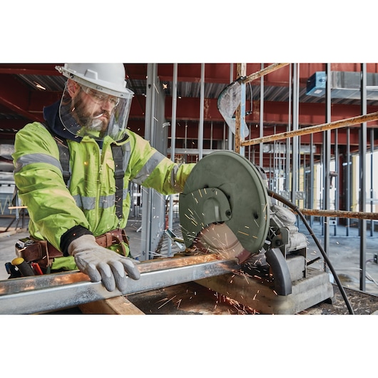 LENOX cutting wheel 1972932 in action on a metal pipe at a construction site with sparks flying.
