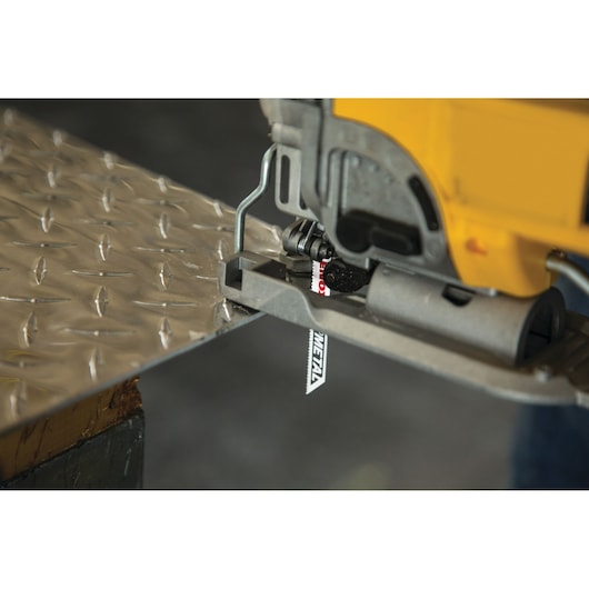 Photo of LENOX 1991567 jigsaw blade cutting metal sheet, close-up side angle.