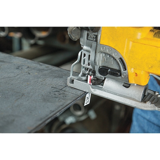 LENOX 1991596 jigsaw blade cutting metal sheet, close-up of blade installed in electric jigsaw.