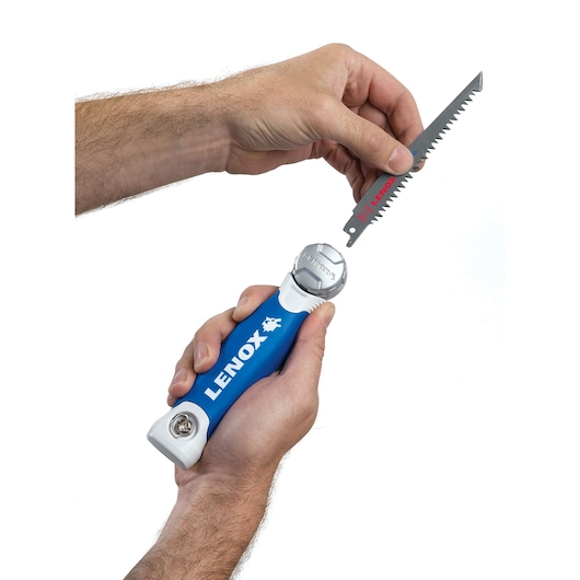Photo of LENOX folding saw handle with blue grip, SKU 20997TFHS618636, hands inserting saw blade, front angle.