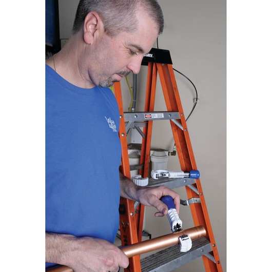 LENOX pipe cutter 21008TC58 used on copper pipe with orange ladder in background.