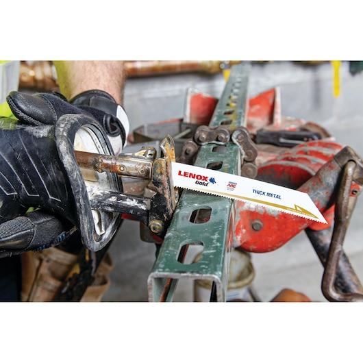 Photo of a LENOX Gold reciprocating saw blade 21067614GR cutting thick metal in an industrial setting.