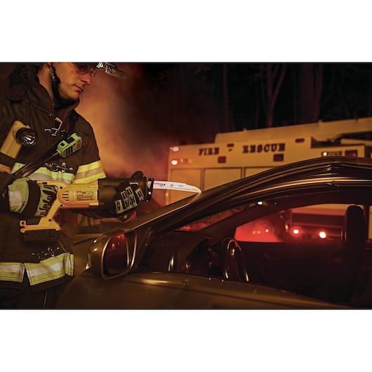LENOX 21221B960GR reciprocating saw blade used by firefighter cutting vehicle door, fire rescue scene at night.