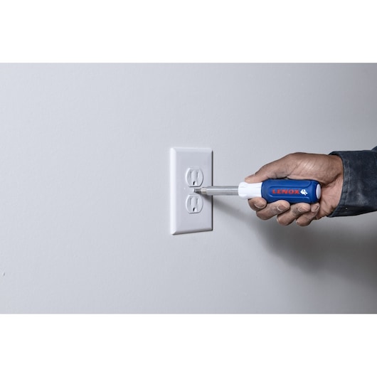 Photo of LENOX 23931_ screwdriver with blue handle used on a wall outlet.