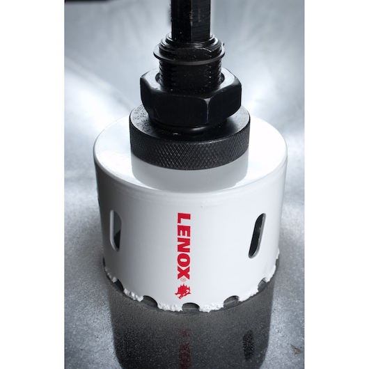 LENOX 2995858CG hole saw with white body and red logo close-up, cutting into metal surface.