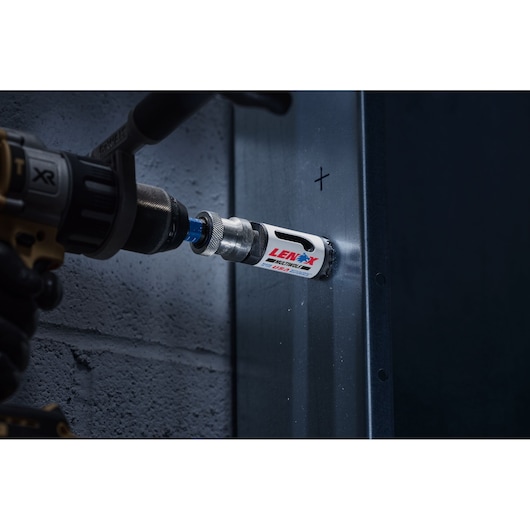 LENOX hole saw 3001818l attached to a drill cutting into metal, close-up action view.