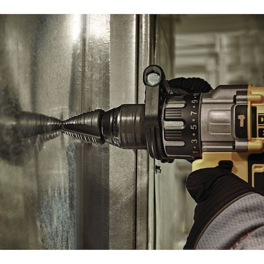 LENOX 30912VB12 step drill bit attached to a power drill in use on a metal sheet, close-up photography.