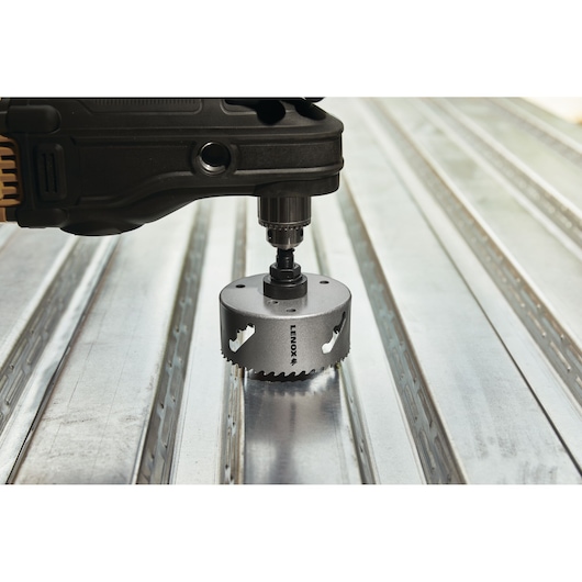 Photo of LENOX hole saw LXAH3412 attached to a power drill on a metal surface.