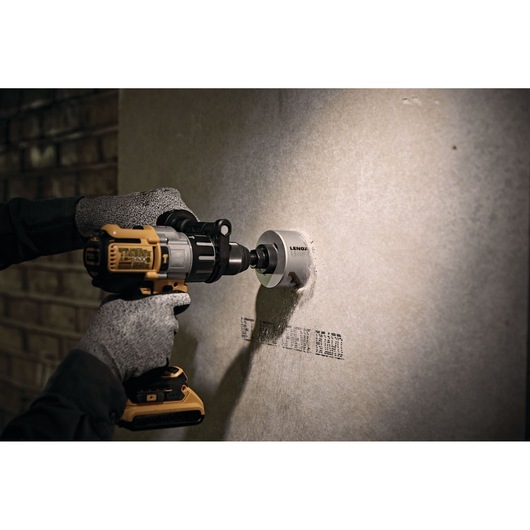 Photo of LENOX LXAH3 hole saw attached to a power drill cutting through drywall.