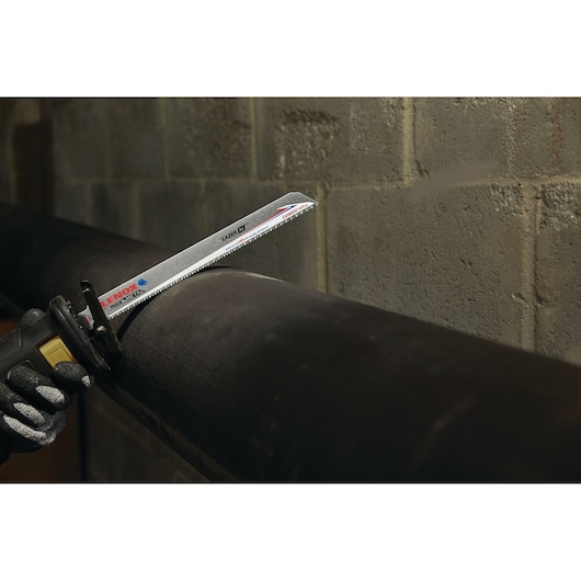 LENOX LXAR12108CT reciprocating saw blade cutting through a black metal pipe against a concrete wall.