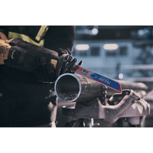 LENOX LXAR9110CT reciprocating saw blade cutting metal pipe in workshop setting.