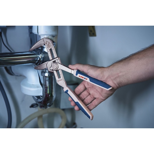 LENOX adjustable groove joint plier LXHT90540 with blue handles gripping a metal pipe during plumbing work.