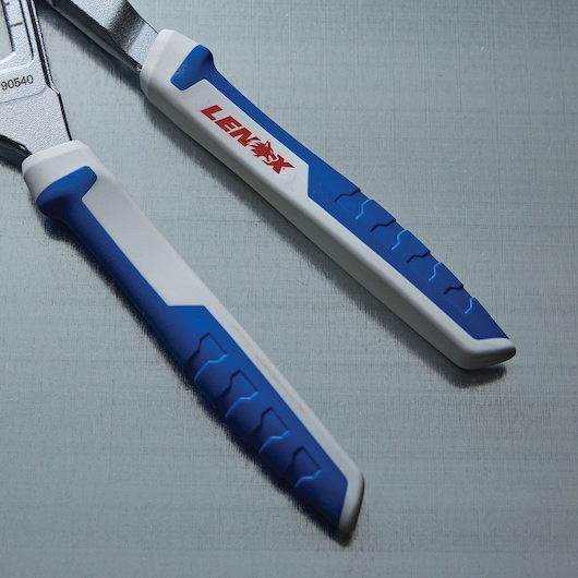 Close-up photo of LENOX LXHT90540 pliers handles with blue and white rubber grips on a metallic surface.