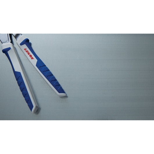 LENOX LXHT90550 pliers with white and blue grip handles, partial top view, on a gray surface.