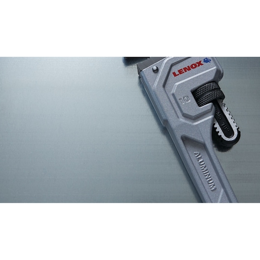 Photo of LENOX LXHT90610 aluminum pipe wrench partial view on metallic surface.