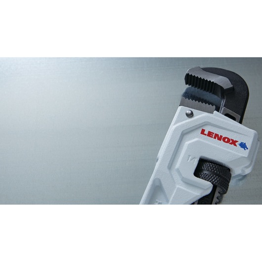 Close-up photo of LENOX pipe wrench LXHT90714 with white handle, angled on a light gray background.