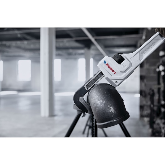 LENOX LXHT90736 pipe wrench gripping a metal pipe in an industrial setting.